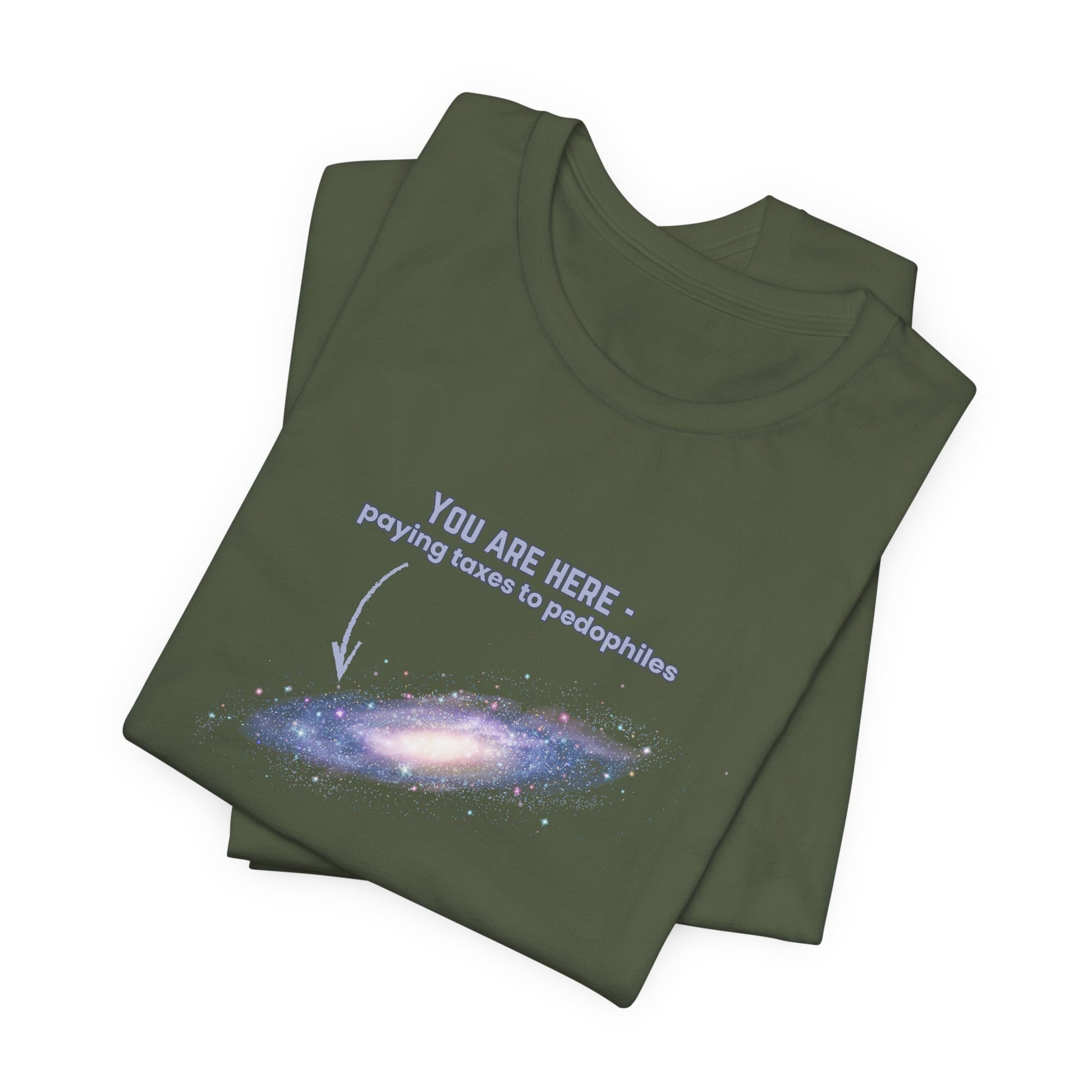 Folded military green t-shirt with graphic of the Milky Way galaxy with an arrow pointing to it and text that says "YOU ARE HERE - Paying taxes to pedophiles" by empowHER by Heidi