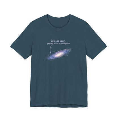 Dark blue t-shirt with graphic of the Milky Way galaxy with an arrow pointing to it and text that says "YOU ARE HERE - Paying taxes to pedophiles" by empowHER by Heidi