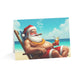 Card with a cartoon Santa Claus lounging on a beach, smoking a cigar and holding a drink.