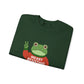 Folded green sweatshirt with the Portland protest frog wearing a sweater displaying 'Merry Resistmas' by empowHERbyHeidi