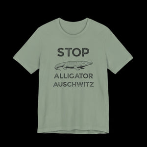 Sage green t-shirt with black text that says "STOP ALLIGATOR AUSCHW*TZ" with alligator graphic on ablack background
