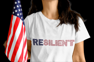Person wearing a white t-shirt with 'RESILIENT' printed in red, blue, and white, holding an American flag.