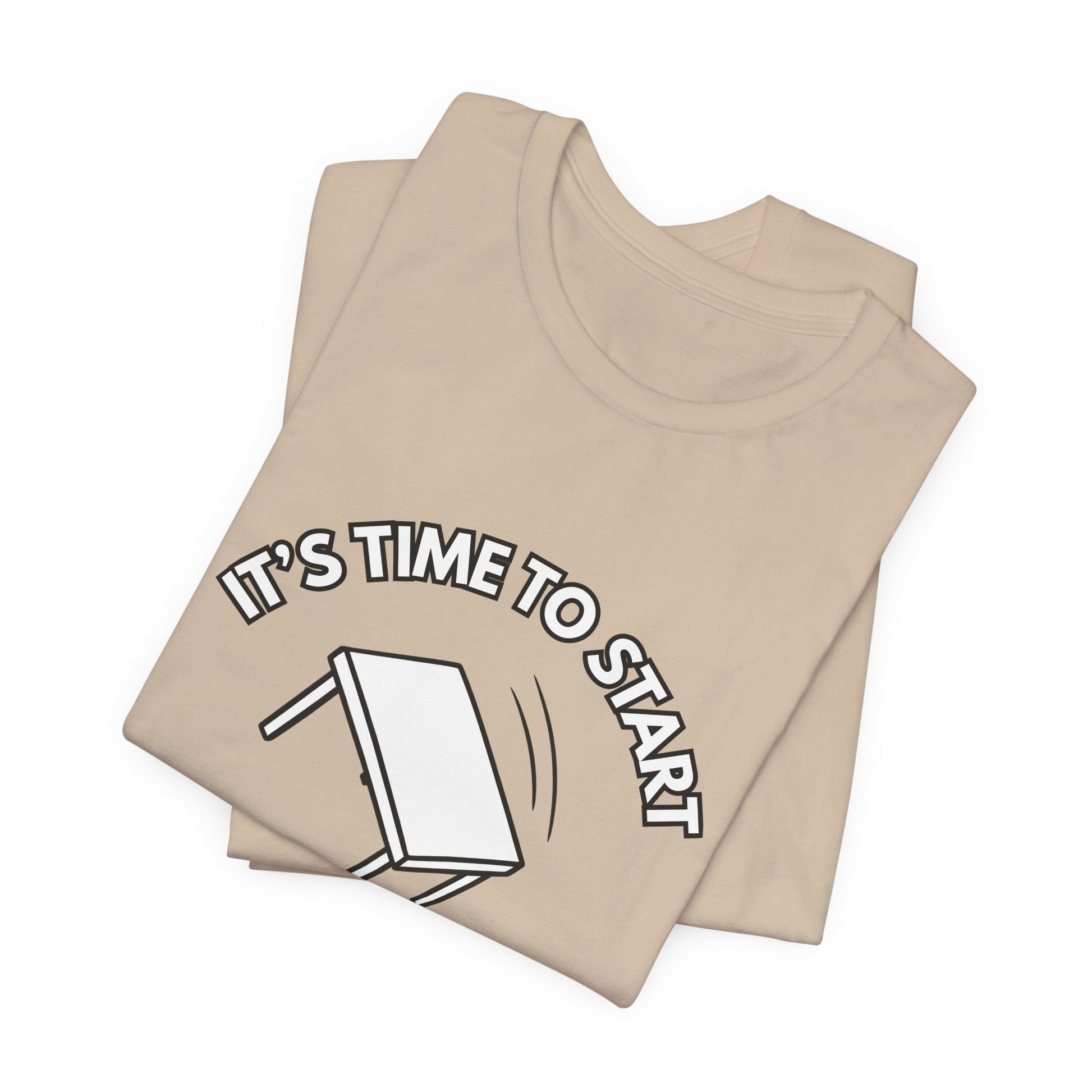 Folded tan t-shirt with a flipping table graphic and text "It's time to start" by empowHER by Heidi