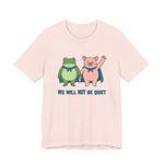 Light pink t-shirt with cartoon frog and pig characters holding hands and text 'WE WILL NOT BE QUIET' on a white background by empowHER by Heidi | protest wear