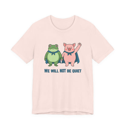 Light pink t-shirt with cartoon frog and pig characters holding hands and text 'WE WILL NOT BE QUIET' on a white background by empowHER by Heidi | protest wear