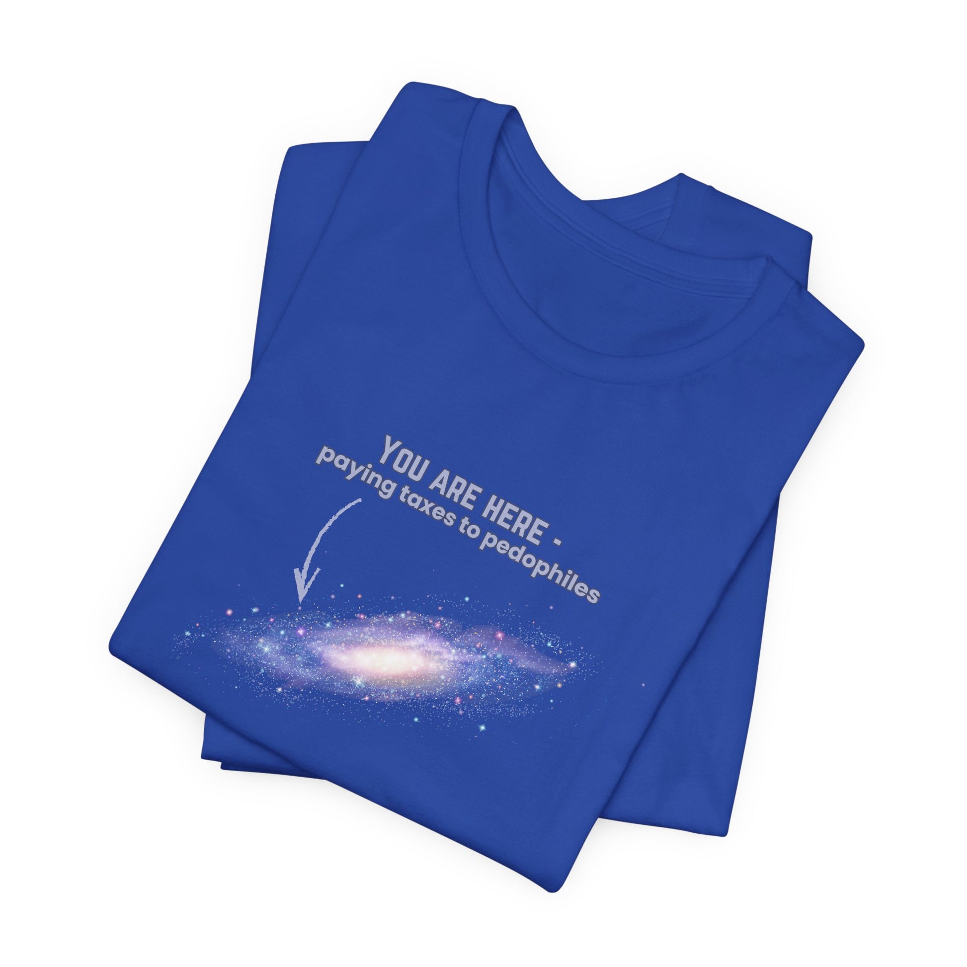Folded royal blue t-shirt with graphic of the Milky Way galaxy with an arrow pointing to it and text that says "YOU ARE HERE - Paying taxes to pedophiles" by empowHER by Heidi
