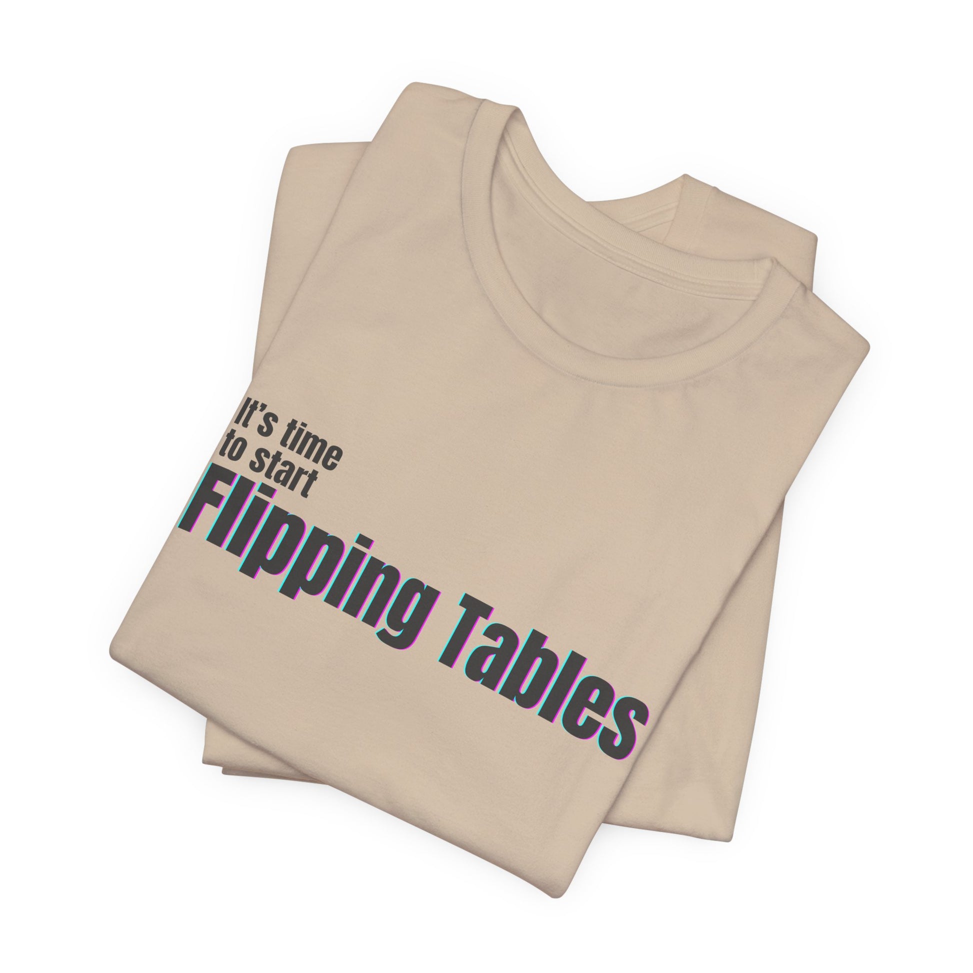 Folded tan t-shirt with text "It's Time to Start Flipping Tables" by empowHERbyHeidi