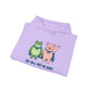 Folded lilac hoodie with cartoon frog and pig characters holding hands and text 'WE WILL NOT BE QUIET' on a white background by empowHER by Heidi | protest wear