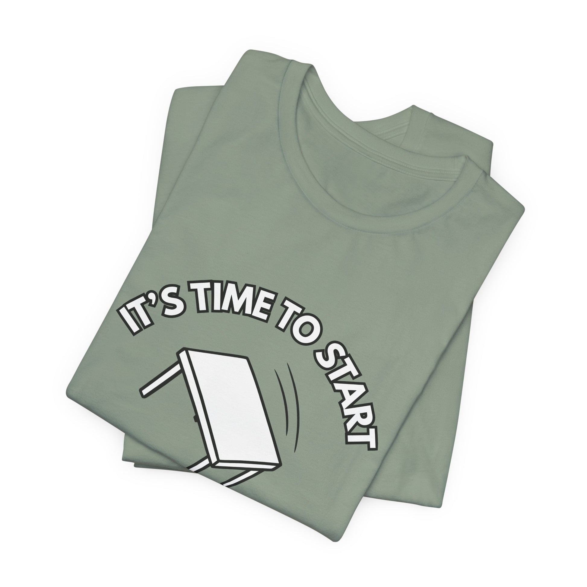 Folded sage green t-shirt with a flipping table graphic and text "It's time to start" by empowHER by Heidi