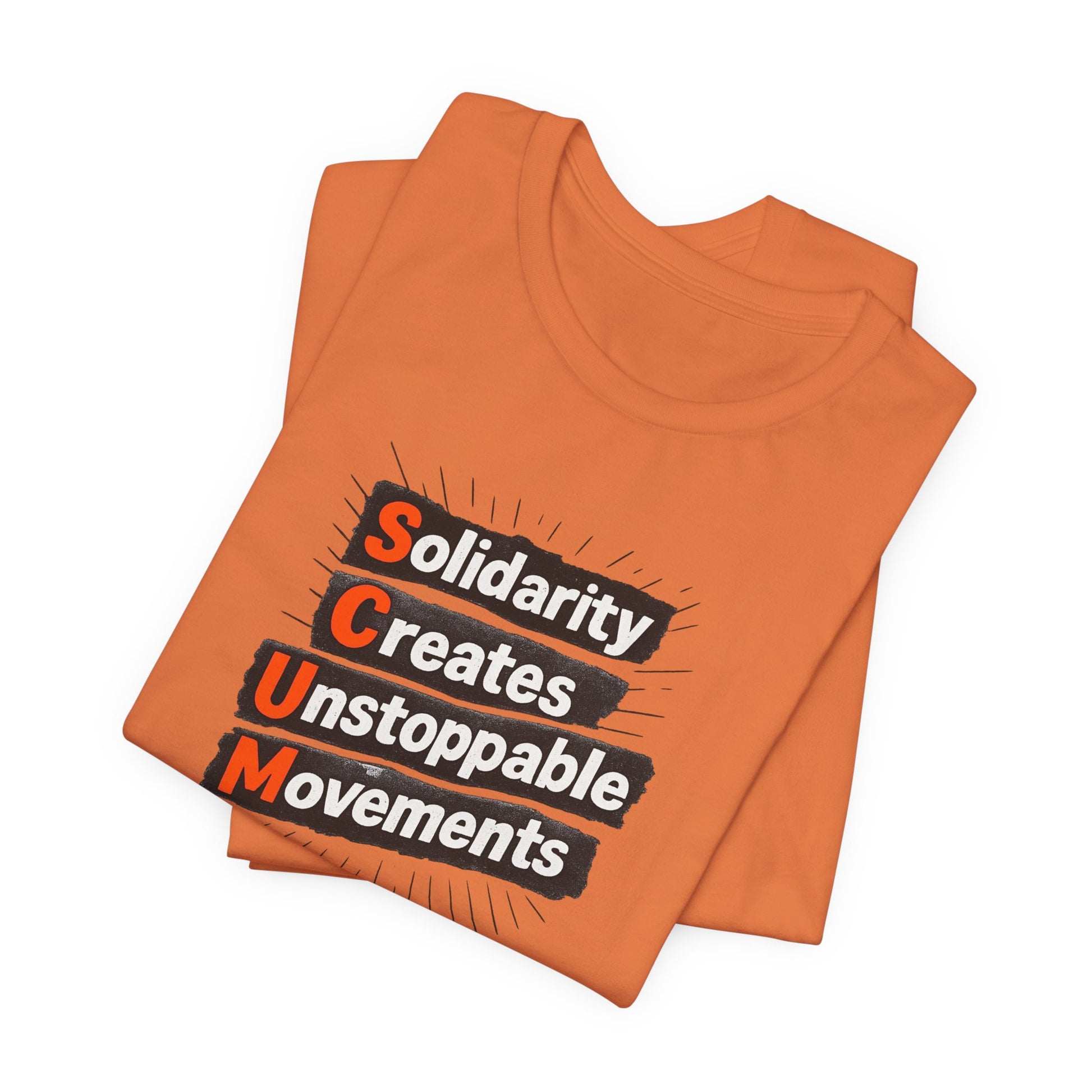 Folded orange t-shirt with motivational quote "solidarity creates unstoppable movements" by empowHER by Heidi
